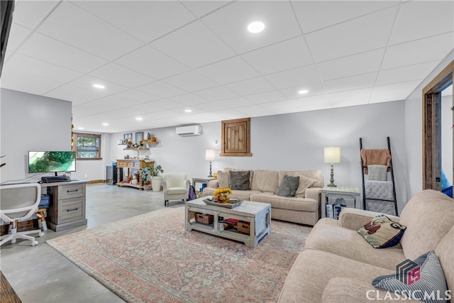 living room featuring an AC wall unit and a paneled ceiling