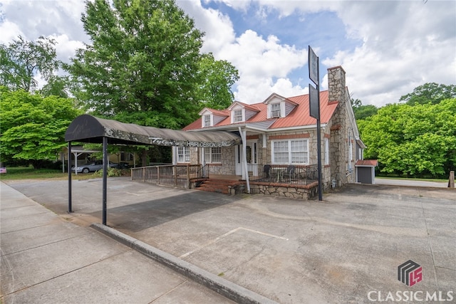 view of front of home with covered porch and a carport