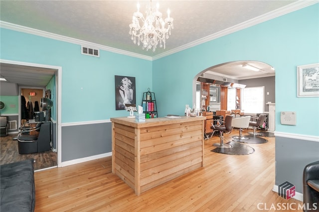 interior space featuring a chandelier, a textured ceiling, hardwood / wood-style flooring, and ornamental molding