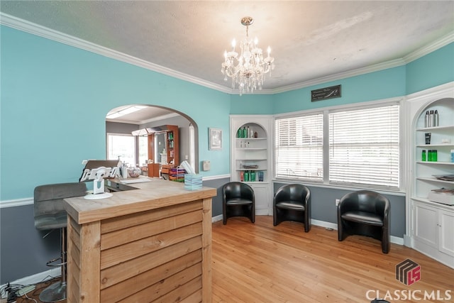 sitting room featuring ornamental molding, a notable chandelier, light wood-type flooring, and a textured ceiling