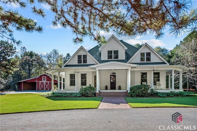 view of front of property featuring an outbuilding, a front lawn, and covered porch