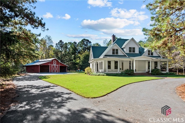 view of front of house featuring a front lawn and an outdoor structure