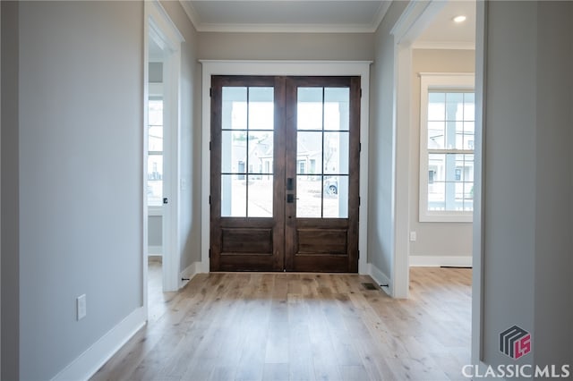 entryway featuring crown molding, french doors, and light hardwood / wood-style floors