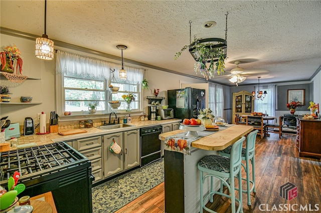 kitchen with dark hardwood / wood-style flooring, ornamental molding, ceiling fan, sink, and black appliances