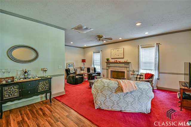 living room featuring a textured ceiling, plenty of natural light, wood-type flooring, and crown molding