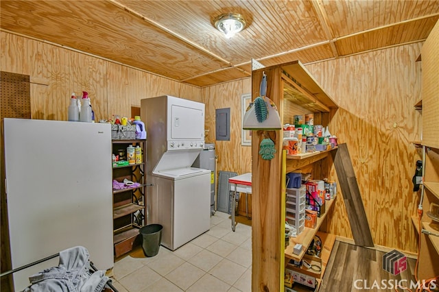 laundry room with electric panel, stacked washer and clothes dryer, wooden walls, light tile patterned flooring, and wood ceiling