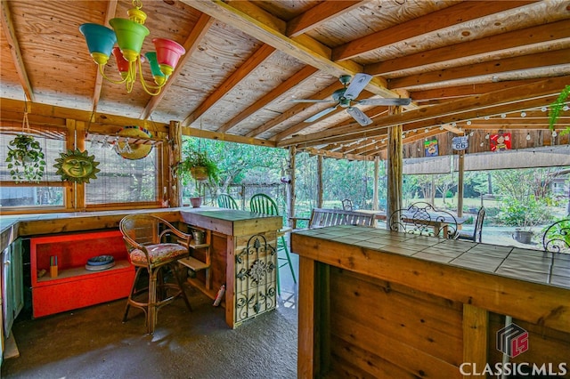 sunroom featuring ceiling fan, a healthy amount of sunlight, and lofted ceiling