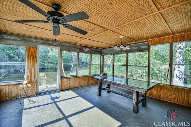 unfurnished sunroom featuring ceiling fan with notable chandelier, a healthy amount of sunlight, and wooden ceiling