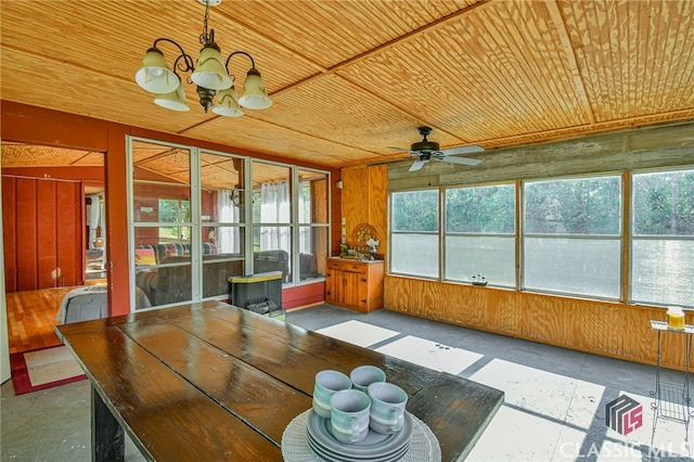 unfurnished sunroom with ceiling fan with notable chandelier