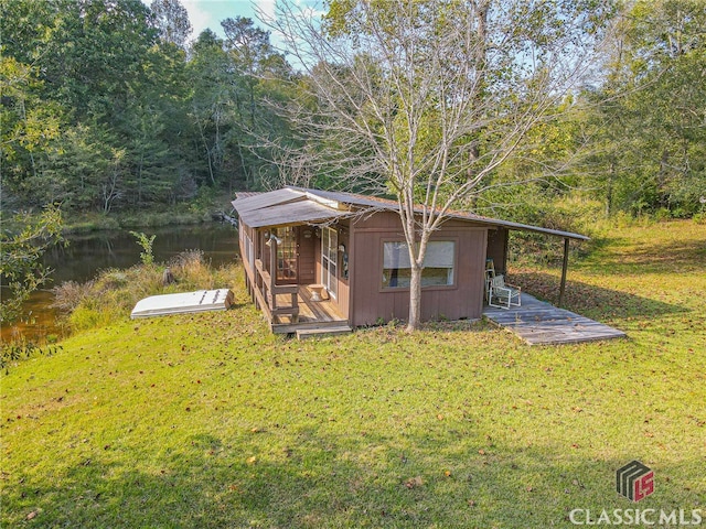 view of outbuilding with a yard and a water view