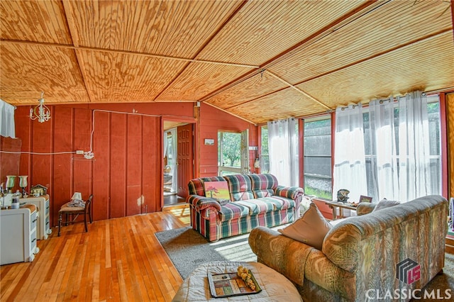 living room with wooden ceiling, wood walls, wood-type flooring, and vaulted ceiling