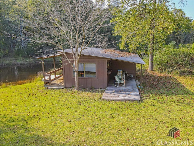 view of outdoor structure featuring a water view and a lawn