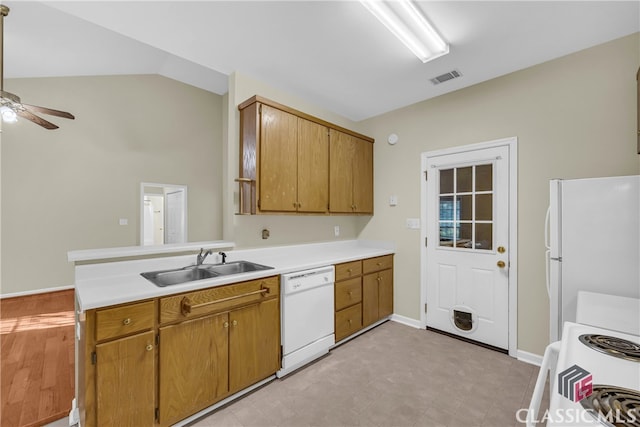 kitchen with kitchen peninsula, white appliances, vaulted ceiling, ceiling fan, and sink