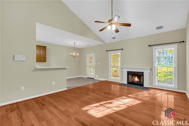 unfurnished living room with light wood-type flooring, high vaulted ceiling, and a wealth of natural light