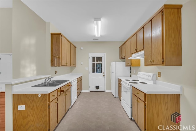 kitchen with kitchen peninsula, white appliances, and sink