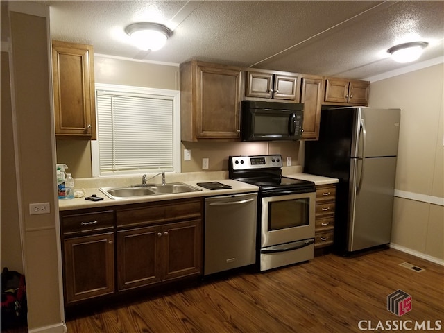 kitchen featuring a textured ceiling, dark hardwood / wood-style flooring, stainless steel appliances, and sink