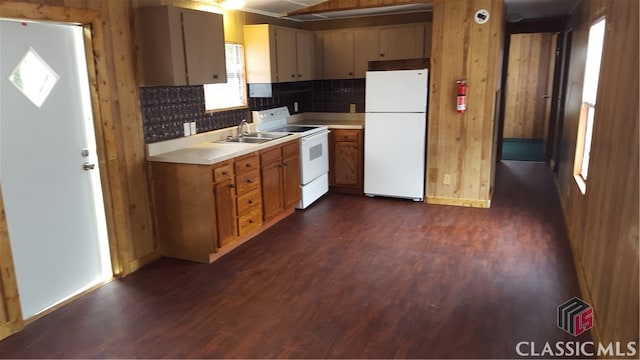 kitchen with white appliances, dark hardwood / wood-style floors, tasteful backsplash, and wooden walls