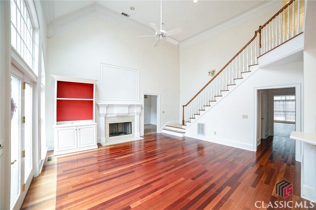 unfurnished living room with hardwood / wood-style flooring, high vaulted ceiling, ceiling fan, and crown molding