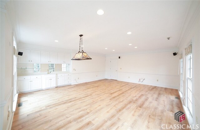 interior space featuring a healthy amount of sunlight, crown molding, and light hardwood / wood-style flooring