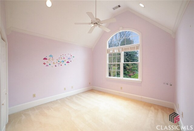 carpeted spare room with vaulted ceiling, ceiling fan, and ornamental molding