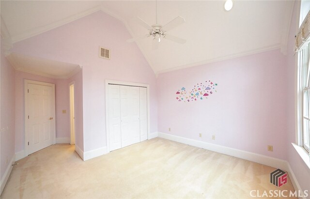 unfurnished bedroom with ceiling fan, crown molding, light carpet, and a closet