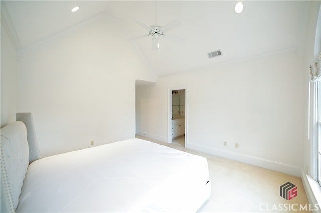 bedroom featuring ceiling fan, lofted ceiling, ensuite bathroom, and light carpet