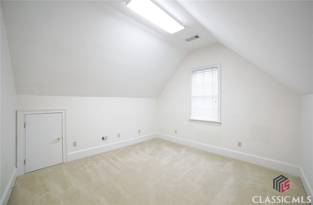 additional living space with light carpet and lofted ceiling