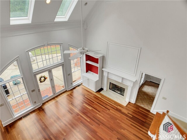 living room featuring a skylight, a wealth of natural light, hardwood / wood-style floors, and high vaulted ceiling