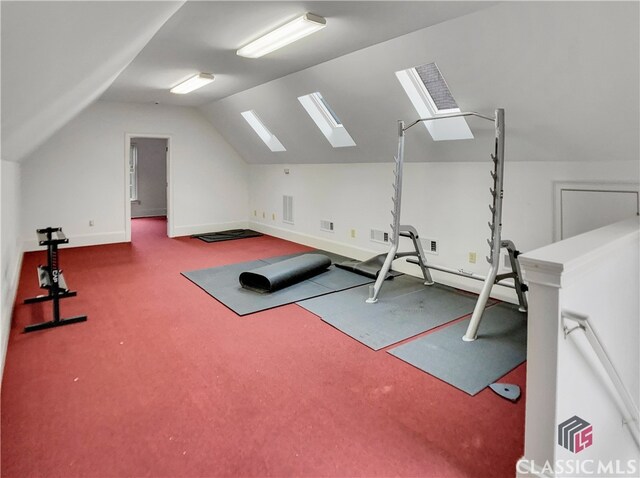 exercise room featuring lofted ceiling with skylight