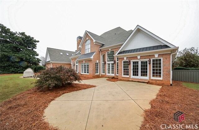 rear view of property featuring a yard and a patio area