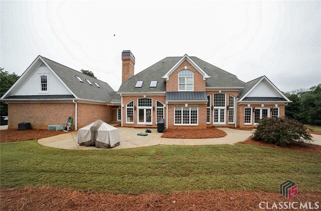 rear view of house featuring a patio area and a yard