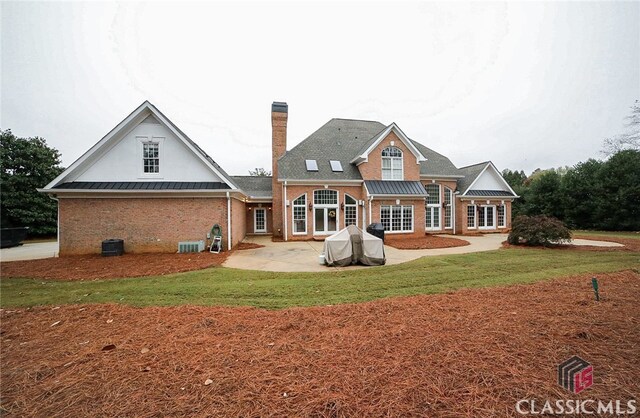 rear view of house with a yard, cooling unit, and a patio area