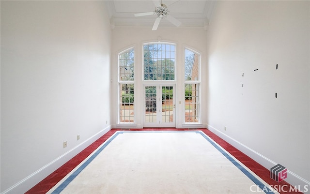 carpeted empty room featuring plenty of natural light, ceiling fan, and a high ceiling