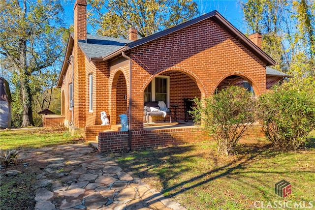 view of front facade featuring a front lawn and a patio