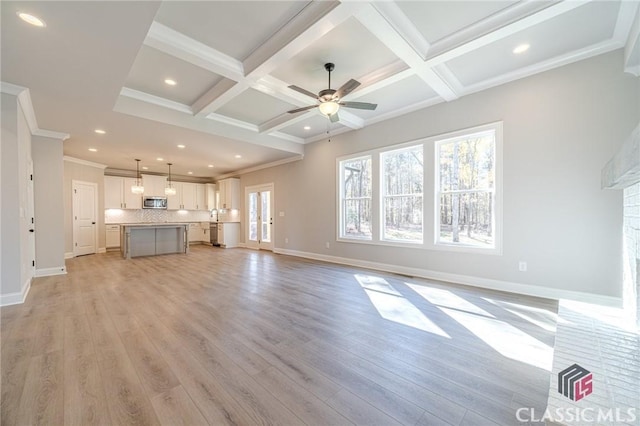 unfurnished living room with light wood-type flooring, ornamental molding, coffered ceiling, beamed ceiling, and a fireplace