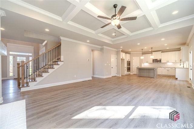 kitchen with stainless steel dishwasher, a kitchen island, light wood-type flooring, and white cabinetry