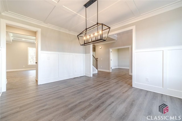 unfurnished room with a chandelier, french doors, crown molding, and wood-type flooring