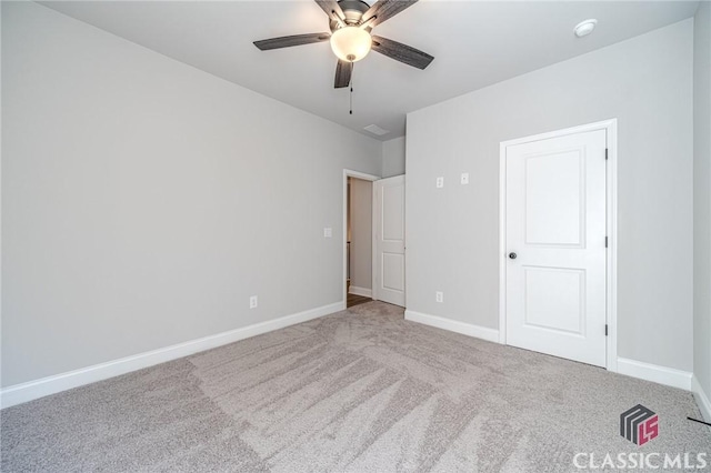 carpeted spare room with ceiling fan