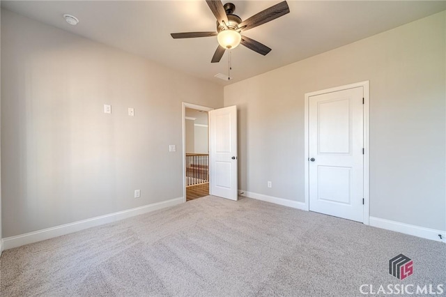 carpeted empty room featuring ceiling fan and ornamental molding