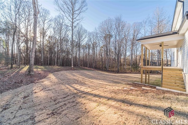 rear view of property with ceiling fan, a yard, and a wooden deck