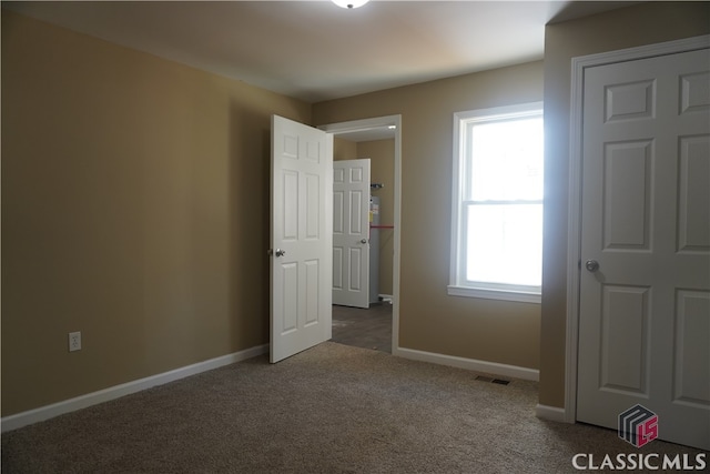 unfurnished bedroom with carpet flooring and multiple windows