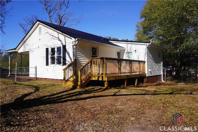 rear view of property featuring a wooden deck