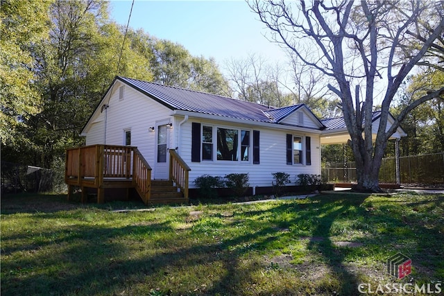 view of front facade with a deck and a front lawn