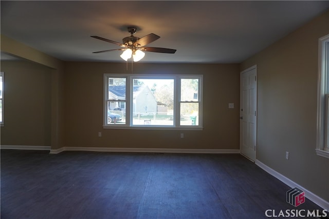 spare room featuring ceiling fan and dark wood-type flooring