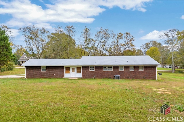 back of property with a lawn and central AC