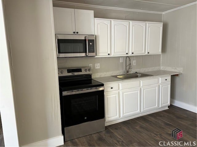 kitchen with dark hardwood / wood-style flooring, stainless steel appliances, crown molding, sink, and white cabinetry