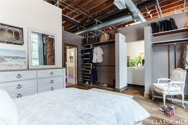 bedroom with wood-type flooring and two closets