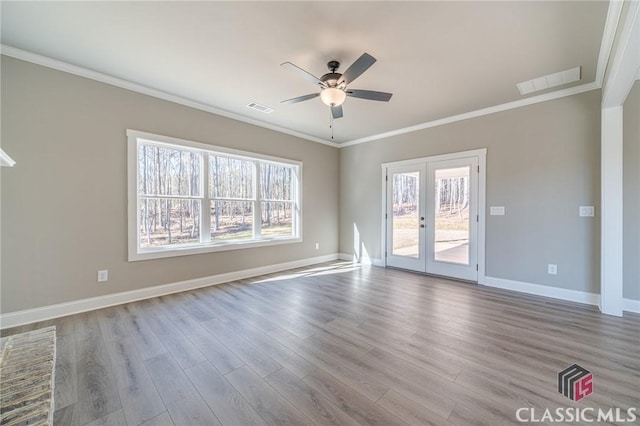 unfurnished room featuring ceiling fan, a healthy amount of sunlight, french doors, and crown molding