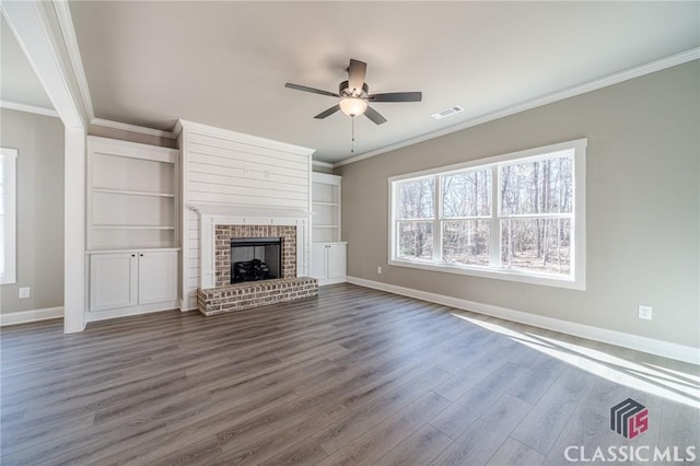 unfurnished living room featuring ceiling fan, a brick fireplace, crown molding, and hardwood / wood-style floors