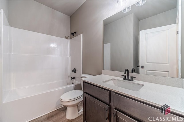 full bathroom featuring toilet, vanity, wood-type flooring, and shower / washtub combination